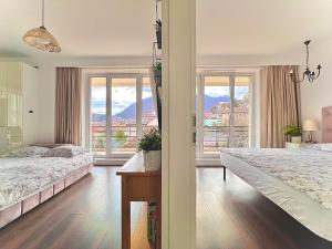 a bedroom with two beds and a view of the mountains at Central Premium Apartment in Braşov