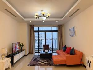 een woonkamer met een oranje bank en een televisie bij BEU Home Vincom Royal City in Hanoi