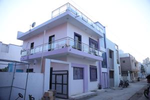 un edificio blanco con balcón en la parte superior en Samyak bunglow, en Dwarka