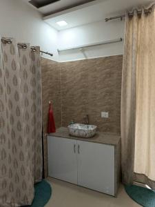 a bathroom with a sink and a shower curtain at 2BHK AC Service Apartment 101 Manjari in Pune +109 photos