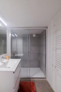 a white bathroom with a shower and a sink at Appartement cosy hyper centre in Épinal
