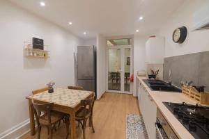 a kitchen with a table and a kitchen with a refrigerator at Appartement cosy hyper centre in Épinal +6 photos