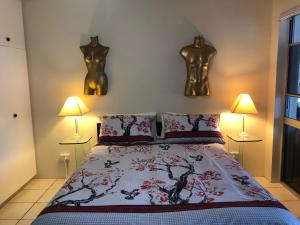 1 dormitorio con 1 cama con 2 estatuas en la pared en phoenixonkingbnb en Buderim