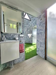 ein Bad mit einem Waschbecken und einem Spiegel in der Unterkunft Finca AveStruz Noche mágica bajo las estrellas in San Isidro