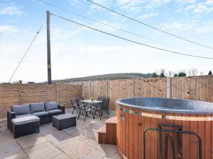 a patio with a hot tub and a table and chairs at Cedar Lodge in Mansfield Woodhouse