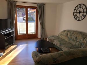 a living room with a couch and a television at Appartement Casa Rancurina in Olivone