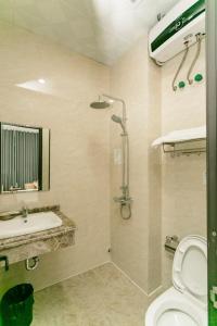 Bảo Ngọc Hotel في Uông Bí: حمام مع مرحاض ومغسلة ودش