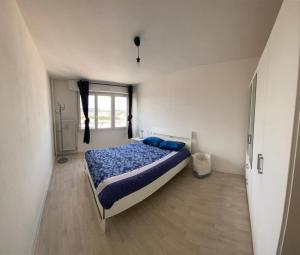 Un dormitorio con una cama con almohadas azules. en F2 65m2 parking privé avec une belle vue, en Metz