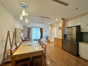 een keuken en een woonkamer met een tafel en een koelkast bij BEU Home Vincom Royal City in Hanoi