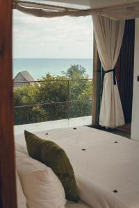 a bedroom with a bed with a view of the ocean at Duna Sonambula in Praia do Tofo