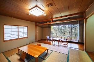 uma sala de estar com uma mesa e uma grande janela em Shiki Resort Ventvert Karuizawa em Karuizawa