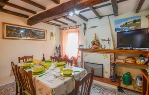 a dining room with a table and a tv at Amazing Home In Camaiore With Wi-fi in Camaiore