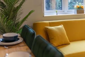 a living room with a yellow couch and a table at Open Mind Property - City Centre & Free Parking in Southampton