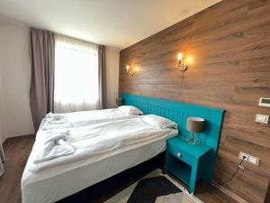 een slaapkamer met een groot bed met een blauw hoofdeinde bij Villa in Ruskovets Resort in Dobrinishte