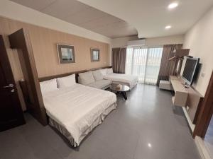 馬公市的住宿－采居海景民宿 ，酒店客房配有床、沙发和电视。