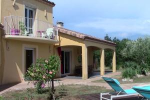 ein Haus mit einem Balkon und einer Terrasse in der Unterkunft Villa de 2 chambres avec piscine privee terrasse et wifi a Lalbenque in Lalbenque