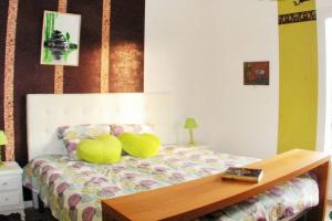 ein Schlafzimmer mit einem Bett mit zwei gelben Kissen darauf in der Unterkunft Villa de 2 chambres avec piscine privee terrasse et wifi a Lalbenque in Lalbenque