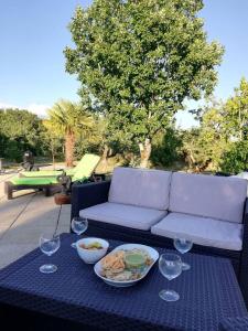 einen Tisch mit einem Teller mit Speisen und Weingläsern in der Unterkunft Villa de 2 chambres avec piscine privee terrasse et wifi a Lalbenque in Lalbenque
