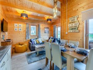 a dining room and living room in a log cabin at Seashell Lodge in Gairloch