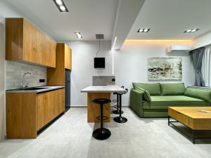 una cucina e un soggiorno con divano verde di GreenKaravan Suite a Salonicco