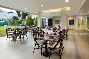 a restaurant with tables and chairs in a room at Kimaya Sudirman Yogyakarta by Harris in Yogyakarta