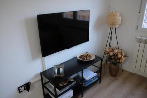 un salon avec une télévision à écran plat sur un mur dans l'établissement Capricho Lostal, à Saragosse 49 autres photos