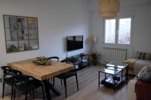 sala de estar con mesa de madera y sofá en Capricho Lostal, en Zaragoza