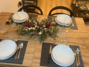 un tavolo con piatti bianchi e una composizione floreale di Capricho Lostal a Saragozza