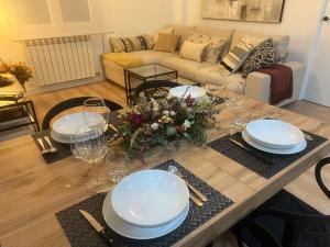 una sala de estar con una mesa con platos y vasos. en Capricho Lostal, en Zaragoza