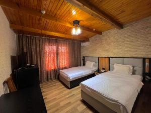 een slaapkamer met 2 bedden en een televisie. bij Byond Hotel in Tasjkent