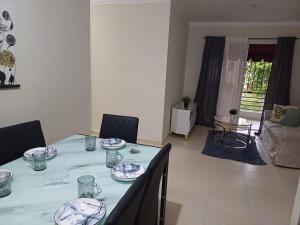 a table with plates and glasses on it in a living room at Bello Apartamento, 2 habitaciones 2 baños Santo Domingo Carmen Renata III in Santo Domingo