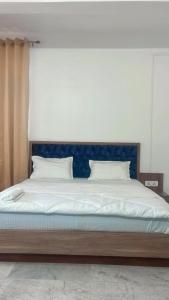 a bedroom with a large bed with a blue headboard at SM LODGE and RESTAURANT in Guwahati