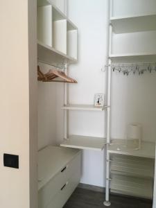 a white closet with white shelving and shelves at Pole Position Rho Milano - Top to reach City centre, Exhibition, Mind, Live Dome, San Siro in Rho
