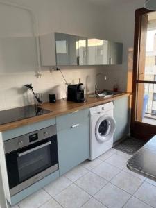 a kitchen with a washing machine and a washer at Appart T3 proche métro -draps et serviettes inclus in Marseille