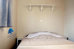 a small bedroom with a bed in a room at Mobilhome Fun and Sun - 4-6 personnes-2 Chambres in Sigean