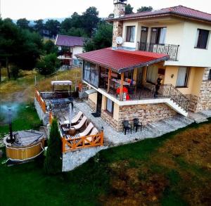an aerial view of a house with a deck and a patio at Divna Guest House in Dospat