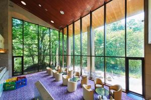 a large room with chairs and tables and large windows at Shiki Resort Belufore Nasu in Nasu