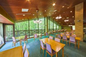 a dining room with tables and chairs and windows at Shiki Resort Belufore Nasu in Nasu