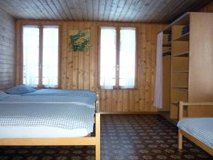 um quarto com 2 camas e 2 janelas em Alpenhof Mountain Lodge em Stechelberg