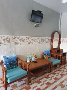 een kamer met een tafel en twee stoelen en een televisie bij สิชล บ้านอุ๊ รีสอร์ท in Sichon