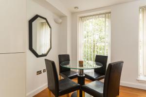 a dining room with a glass table and black chairs at Apartment in the heart of Cardiff City Centre in Cardiff