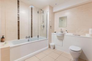 a bathroom with a tub and a toilet and a sink at Apartment in the heart of Cardiff City Centre in Cardiff