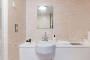 a white bathroom with a sink and a mirror at Apartment in the heart of Cardiff City Centre in Cardiff +14 photos