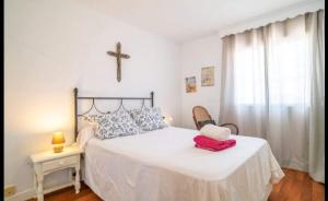 - une chambre dotée d'un lit avec une croix sur le mur dans l'établissement Azahar - Vista Mar, à Rincón de la Victoria