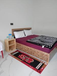 1 dormitorio con cama y mesa con alfombra en Govind Palace, en Uttarkāshi
