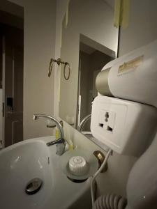 een witte badkamer met een wastafel en een spiegel bij Aladnan hotel in Aqaba