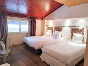 1 dormitorio con 2 camas y ventana en Logis Hôtel Les Pages, en Lunéville