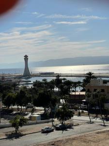 - une vue sur la plage et l'océan avec une tour dans l'établissement Aladnan hotel, à Aqaba