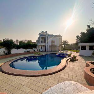 a large swimming pool in front of a house at pool loft in Jaipur