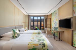 a hotel room with two beds and a flat screen tv at Courtyard by Marriott Shanghai International Tourism and Resorts Zone in Shanghai